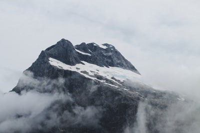 雪的山被云包围着
